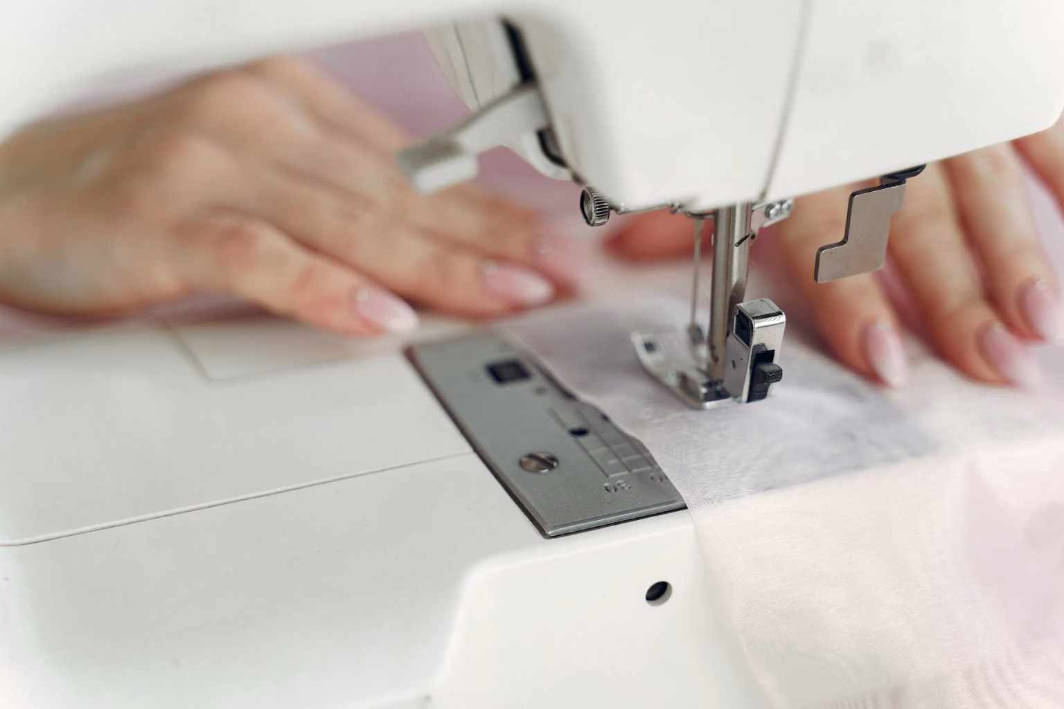 person sewing with a white sewing machine