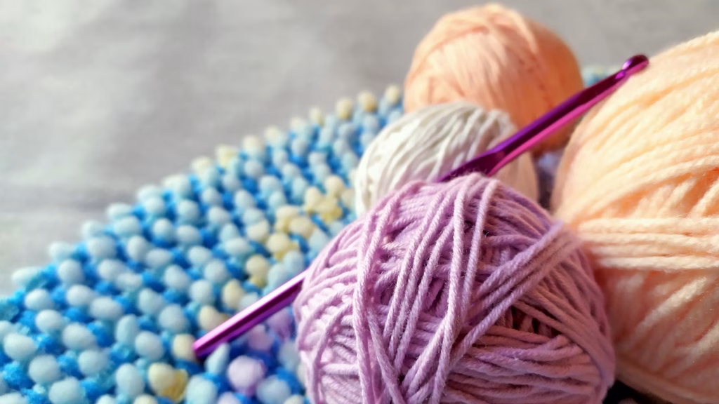 close up photo of a crochet hook and colorful yarns