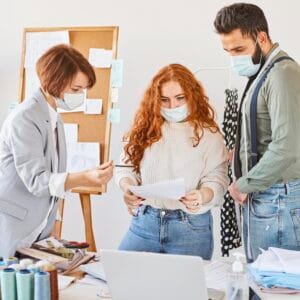 group fashion designers working atelier with medical masks paper